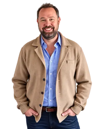 Dan Hardee smiling in a tan cardigan and blue shirt